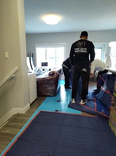 Movers preparing furniture for transport